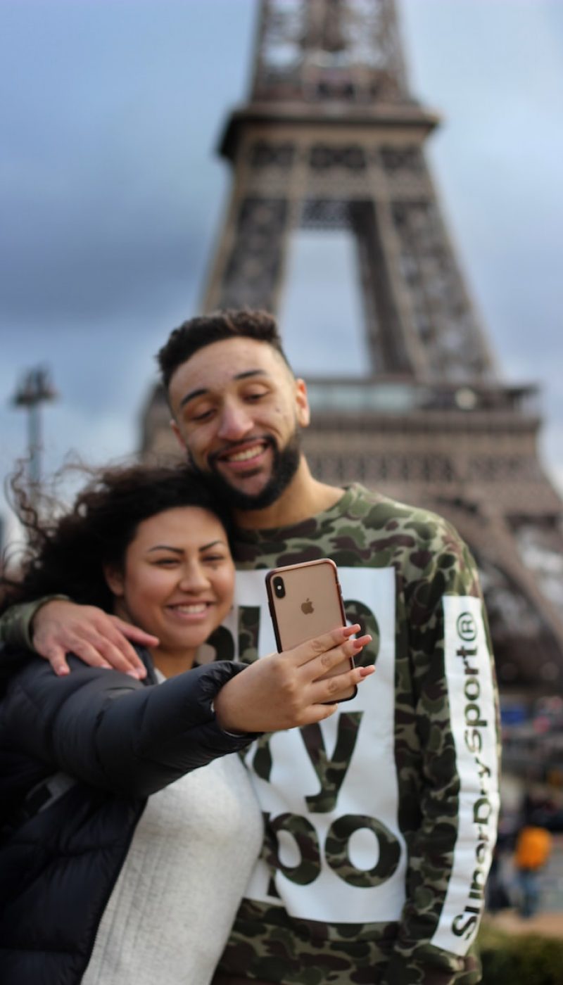 man and woman taking picture near Eiffel Tower in Paris